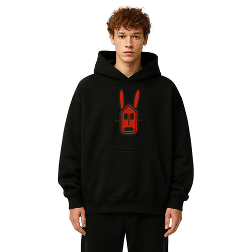 Model wears black hoodie with red crimson Mali Dogon African Mask at the center chest on a solid white background