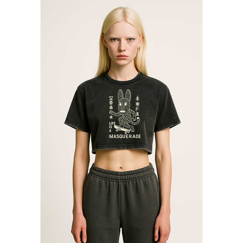 A model facing forward wears nomad_07 women's cropped Solar Patina t-shirt in Onyx with Masquerade_07 Dogon-Adinkra fusion graphic front view