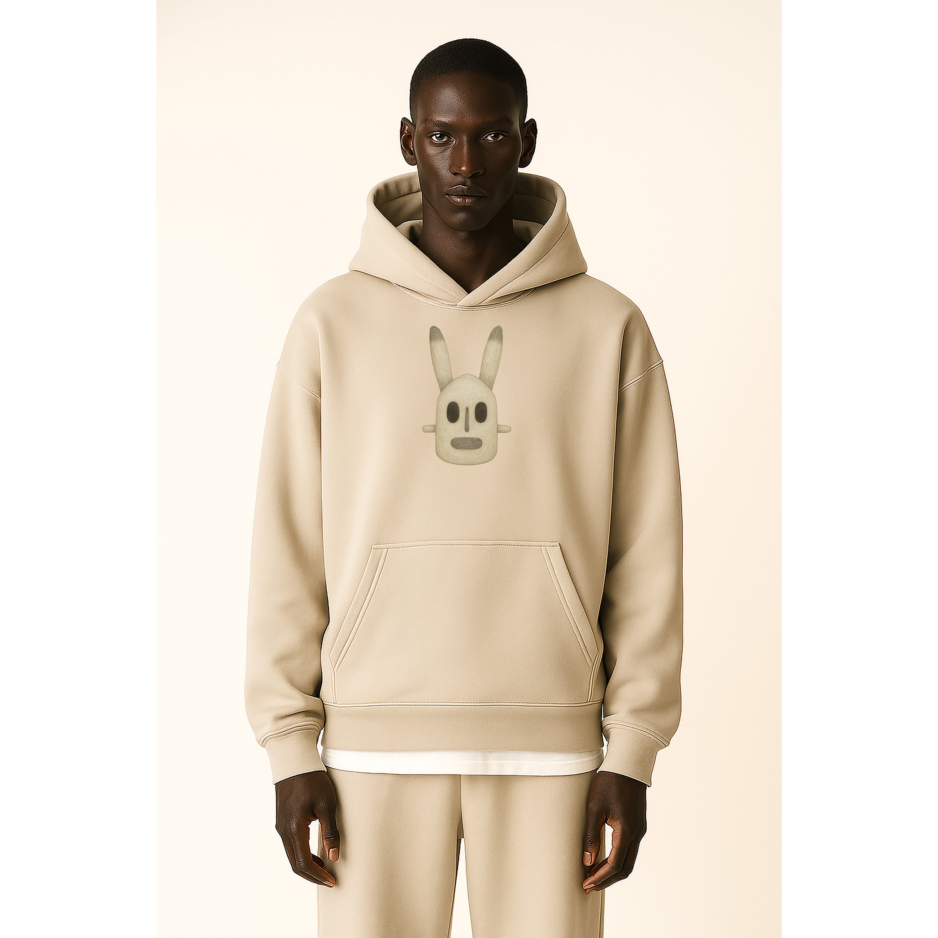 model wears beige hoodie with phantom Mali Dogon graphic and beige sweatpants