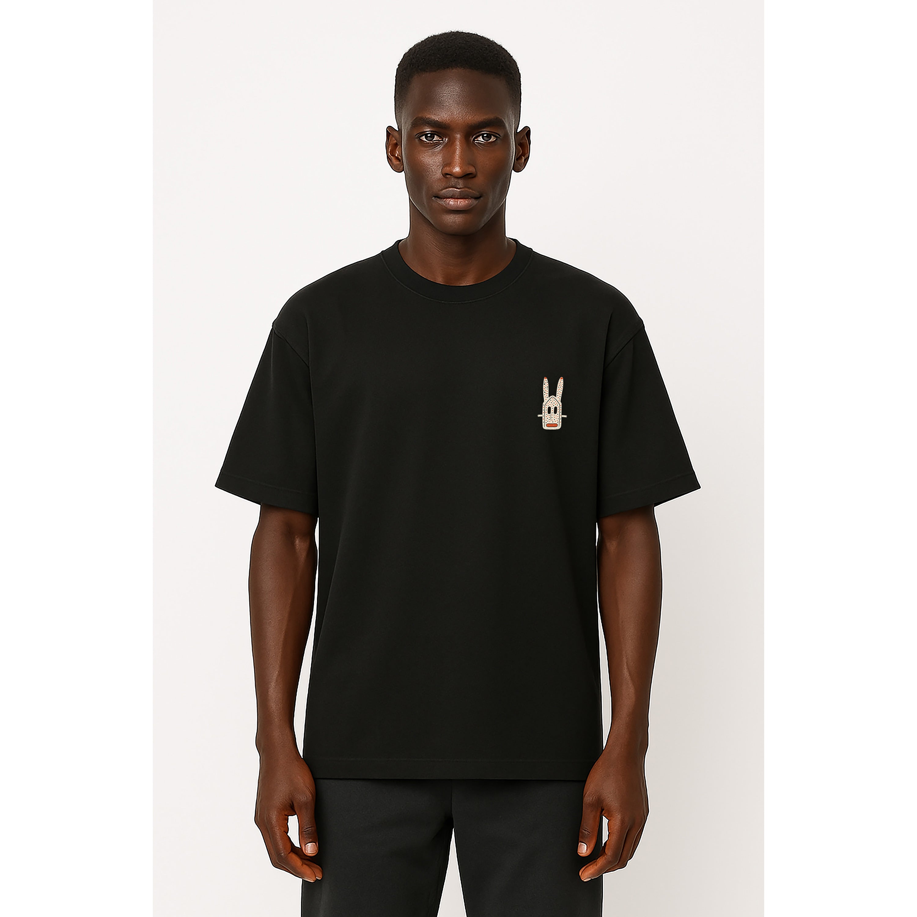 A model wears unisex Onyx heavyweight T-shirt with small Dogon Rabbit chest graphic in cultural fusion style.