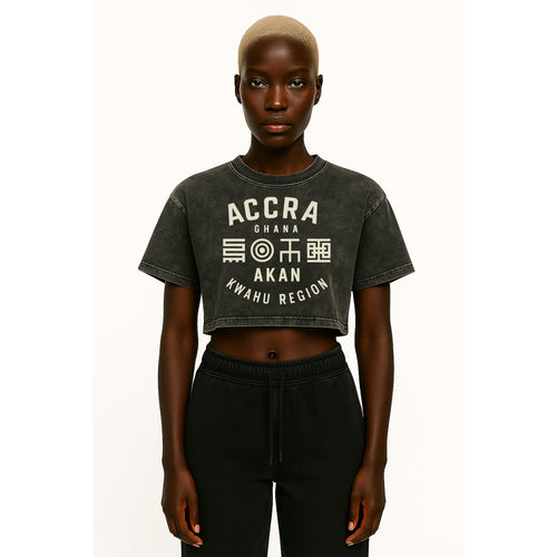 A model wears nomad_07 cropped Solar Patina t-shirt in Onyx with Accra Ghana Script graphic front view