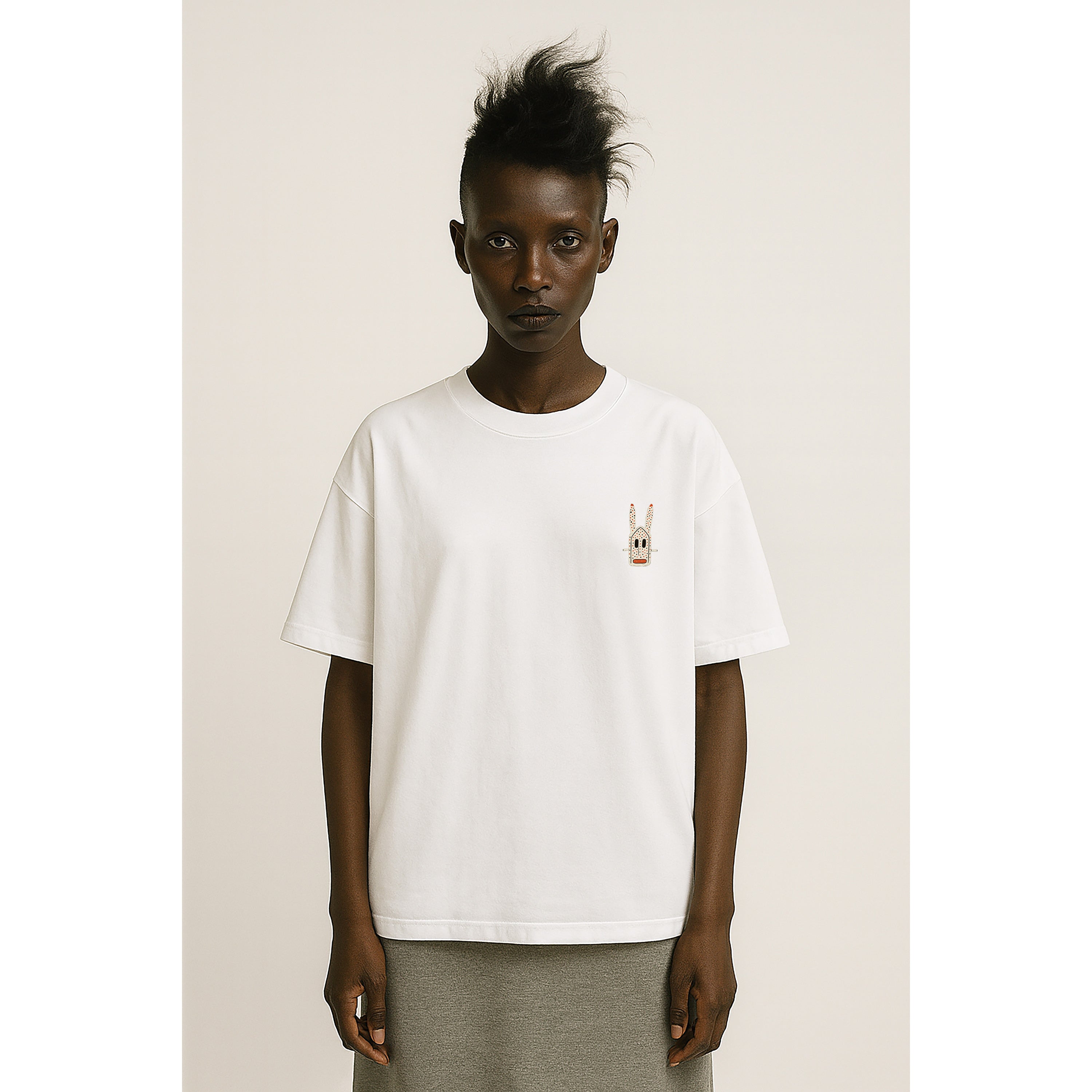 model wears Unisex Chalk white heavyweight T-shirt with small Dogon Rabbit chest graphic in cultural fusion style.