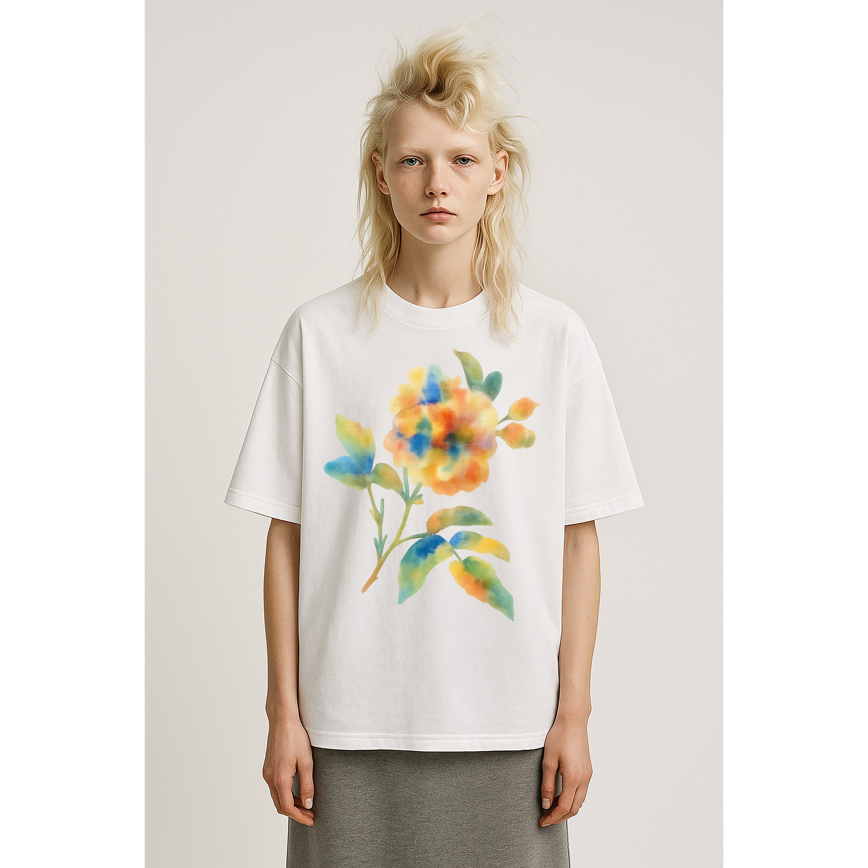 Model wears oversized heavyweight white tee shirt with large watercolor floral multicolor print on solid background