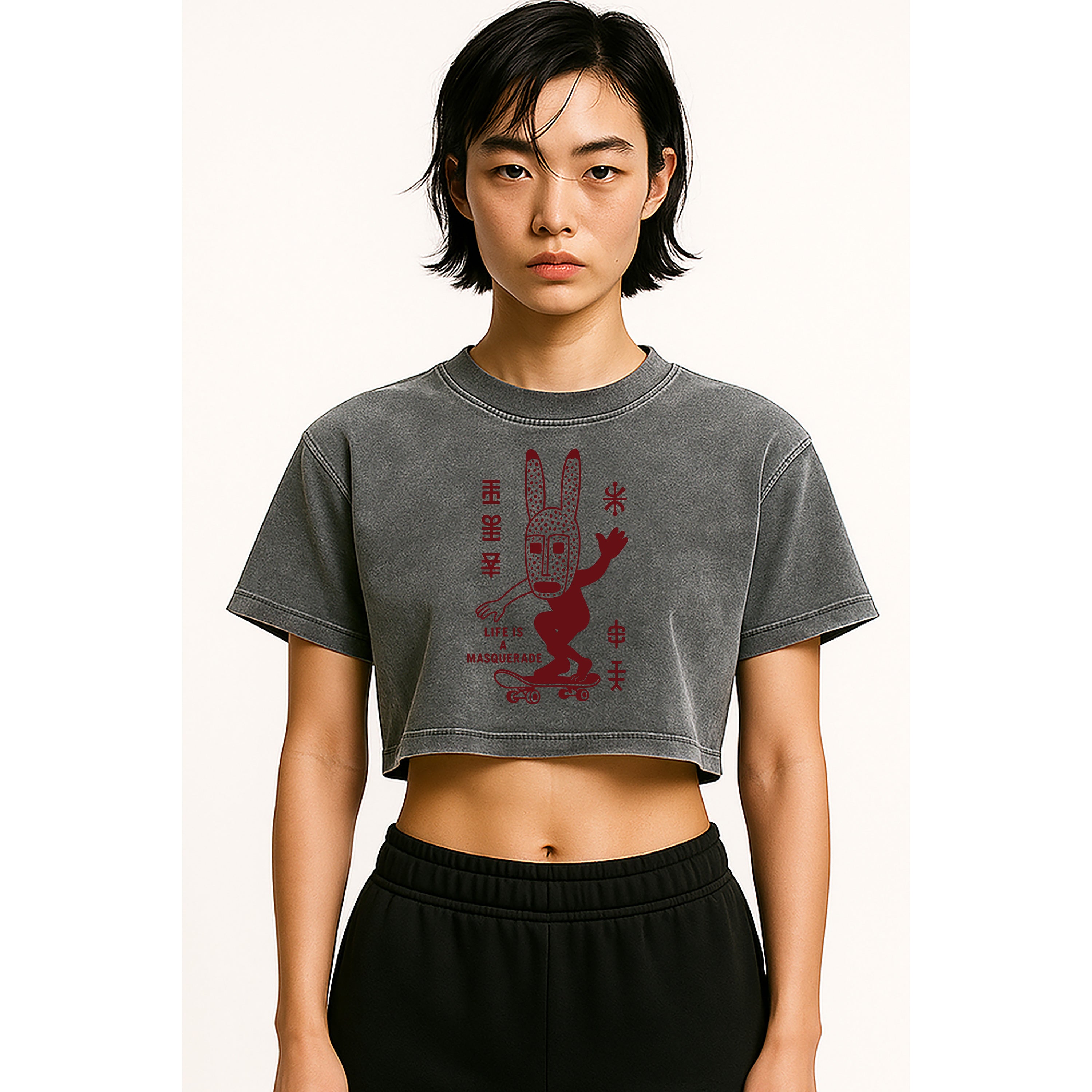 A model wears the nomad_07 women's cropped Solar Patina t-shirt in Ash Grey with Dogon Drift skater graphic front view